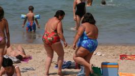 Dicke fette Frauen im Badeanzug am Strand